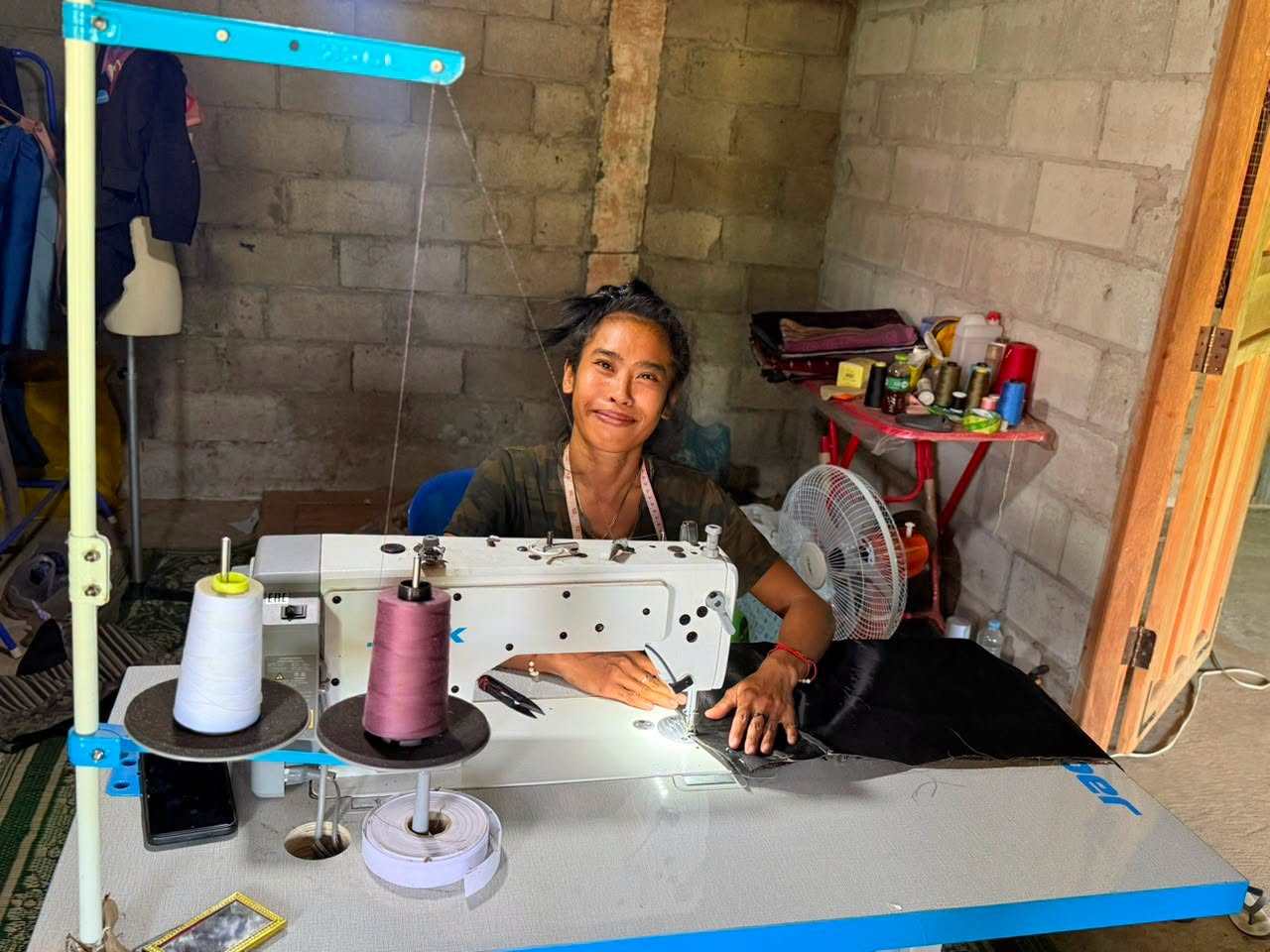 A young tailor working from her home workshop