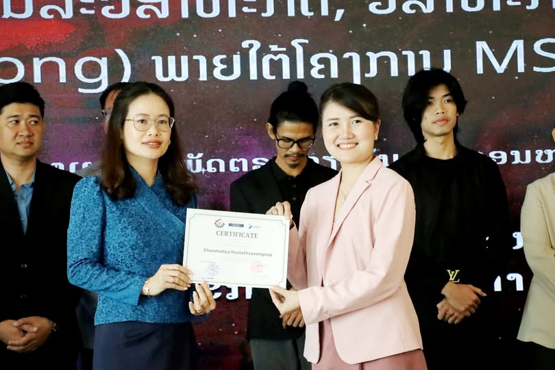 A business owner receiving her B-Strong certificate