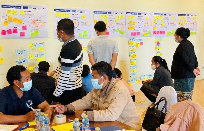 Participants discussing priorities in front of workshop boards