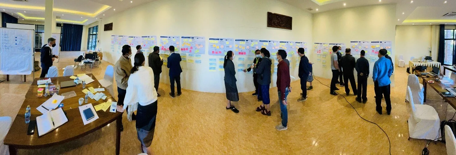 Participants reviewing workshop outputs across a large meeting room