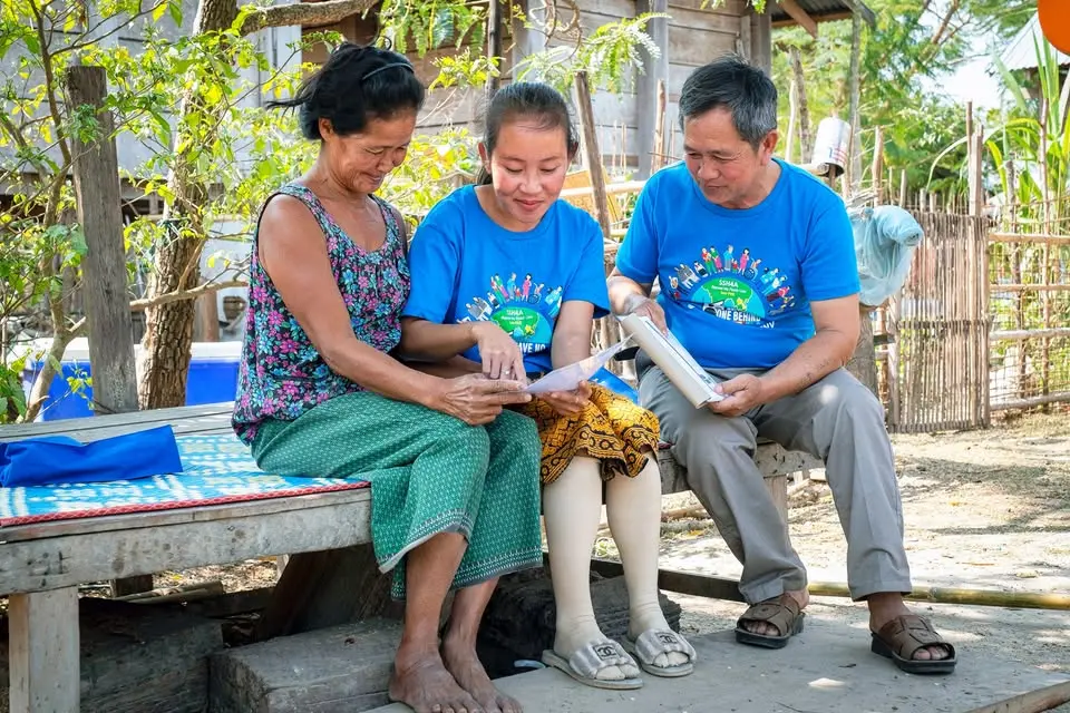 Nutrition team members talking with a woman in a rural community