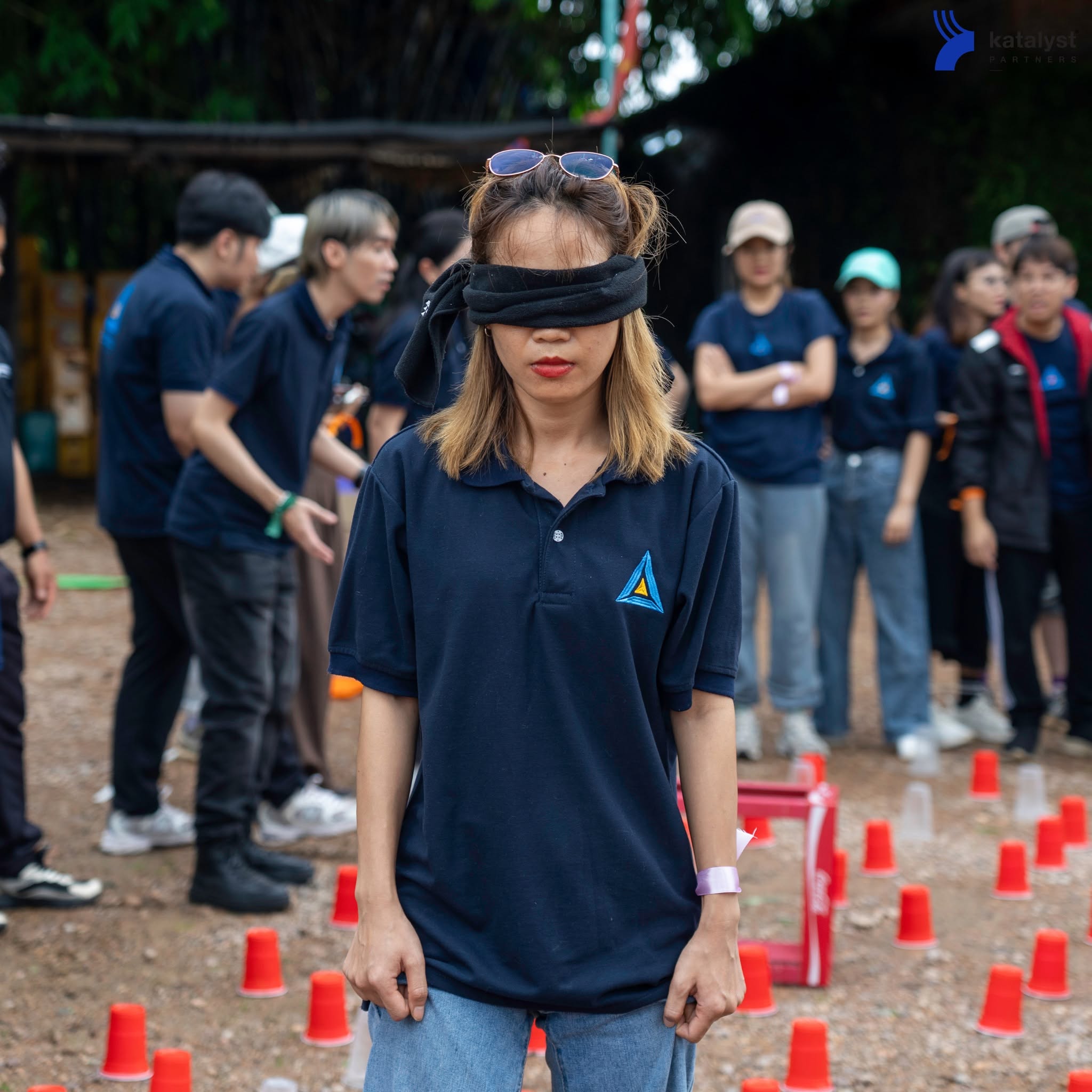 A Bizgital participant taking on a blindfold challenge with colleagues outdoors