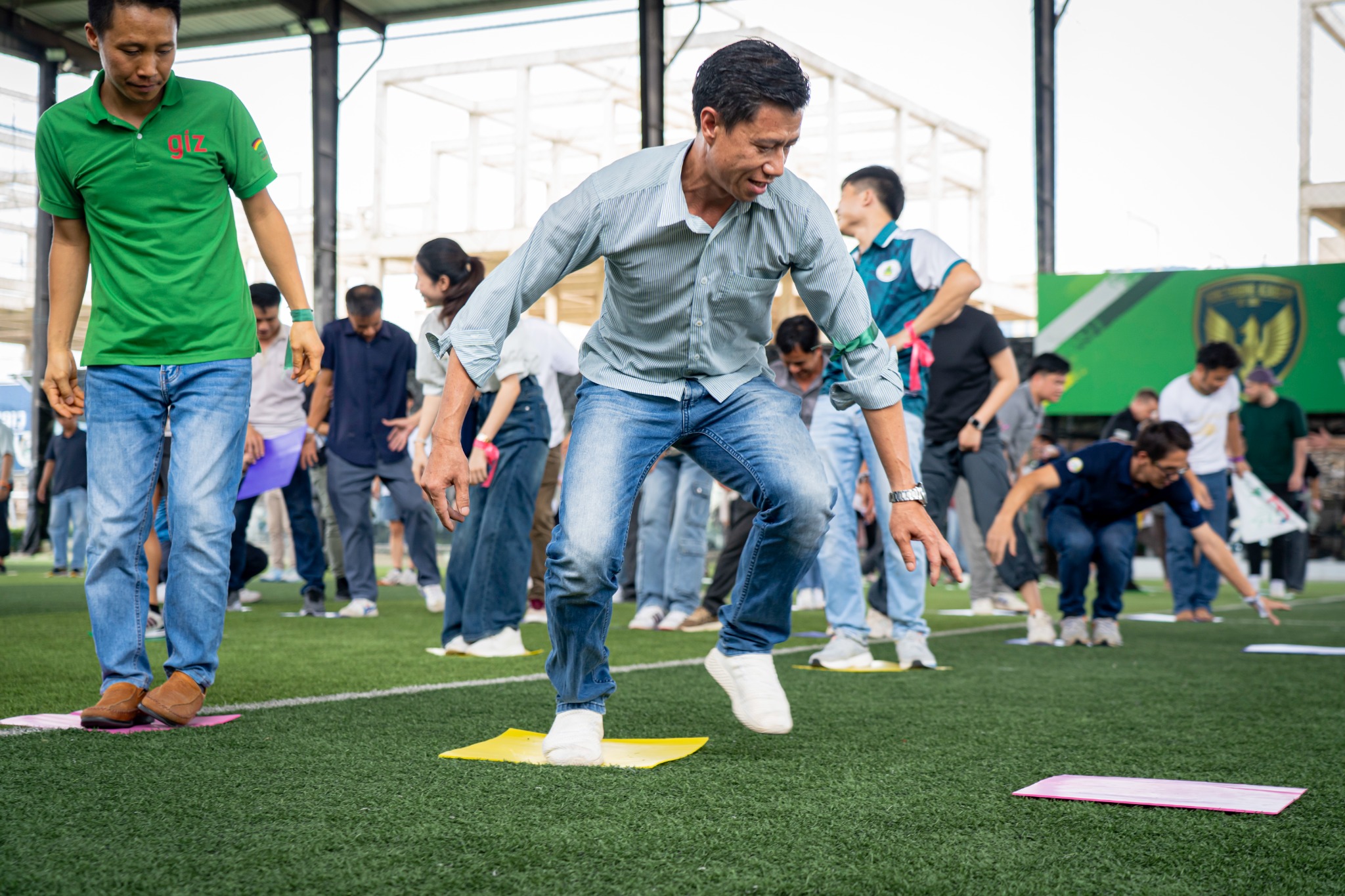 CLIPAD participants concentrating on an active team challenge on a sports field