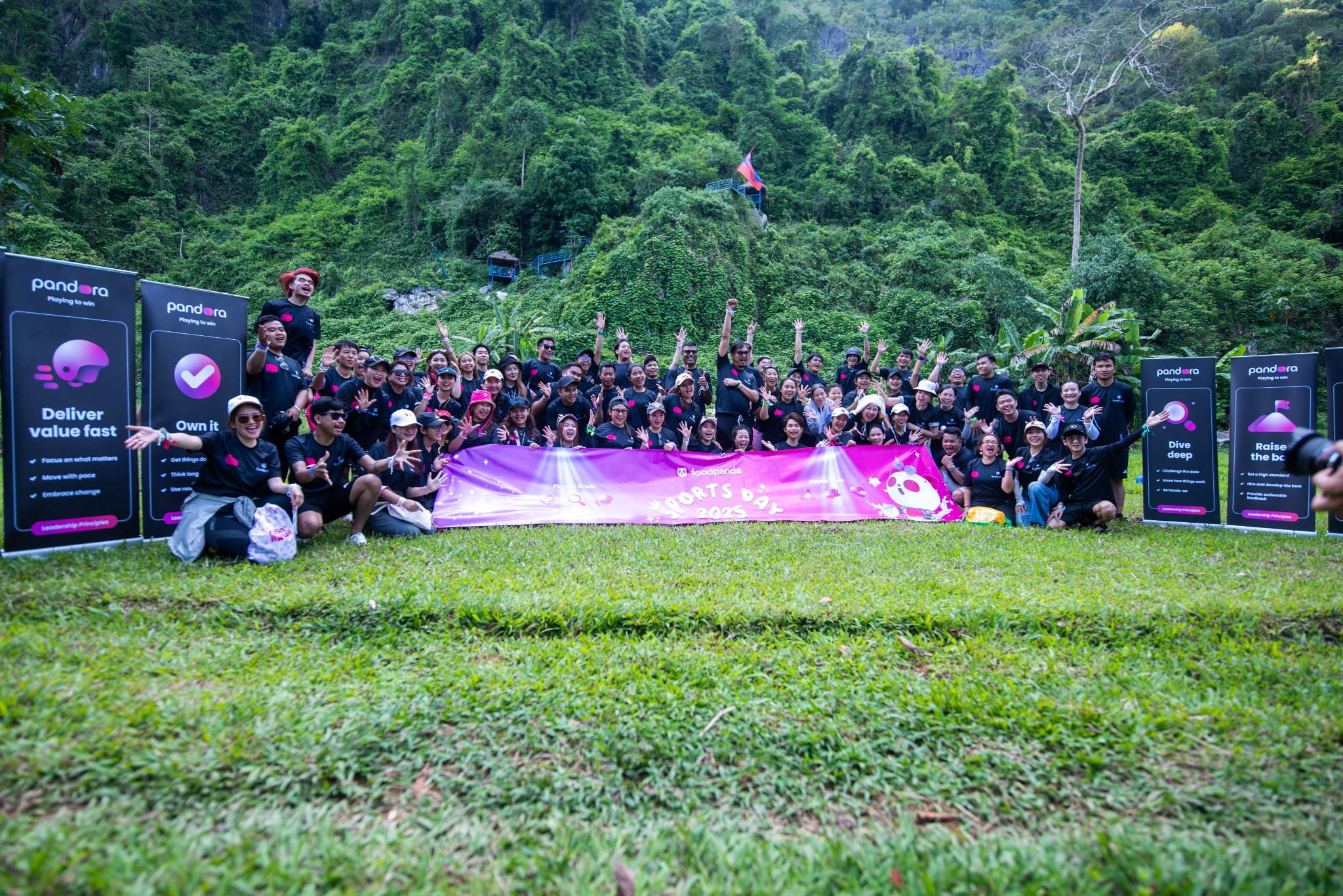 The foodpanda team celebrating together in front of the Vang Vieng mountains
