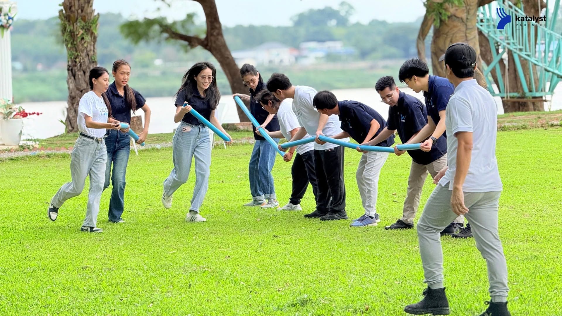 LOCA colleagues working together on an outdoor challenge with blue tubes