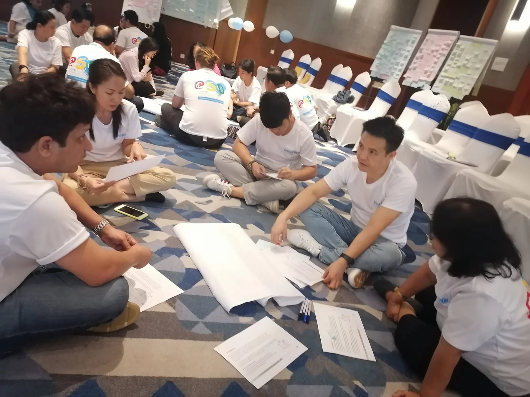 UNICEF colleagues discussing ideas and recording their thinking during their 50th anniversary retreat in Laos